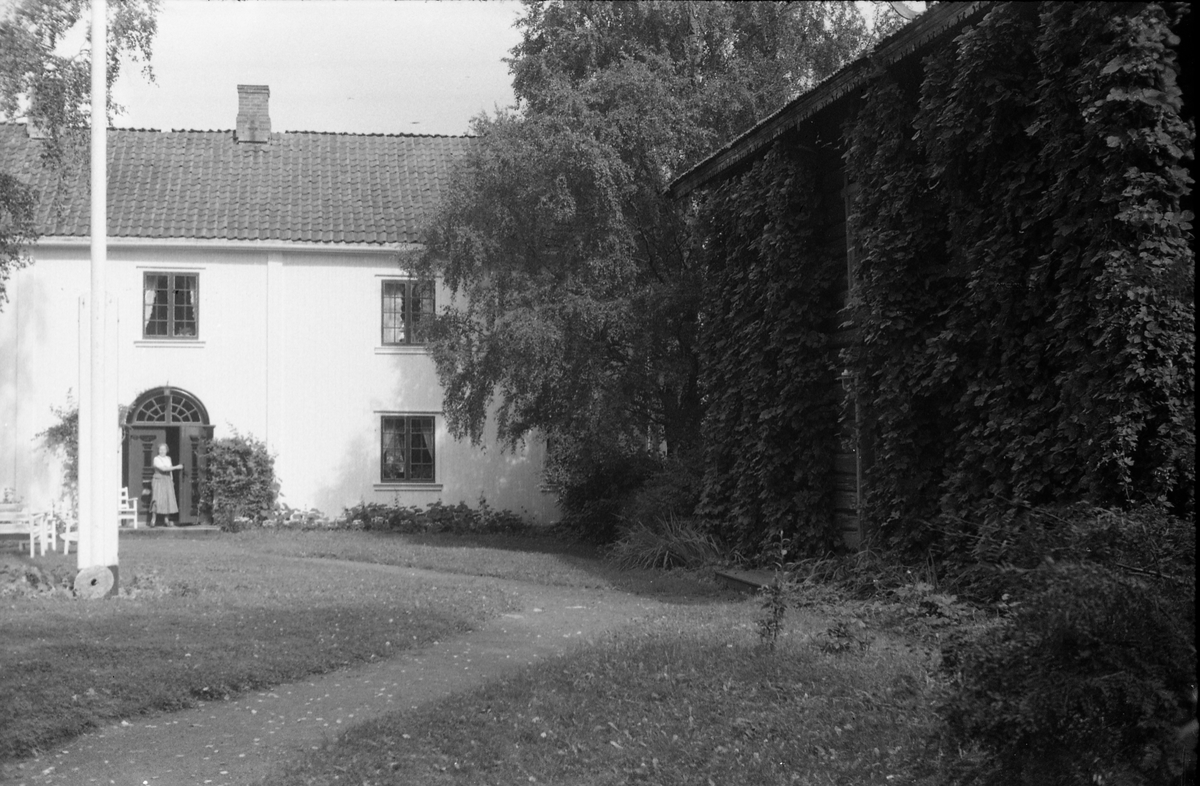 Deler av fasade og gårdsplass trolig på Skaugerud Nordre på Kolbu. Åtte bilder.