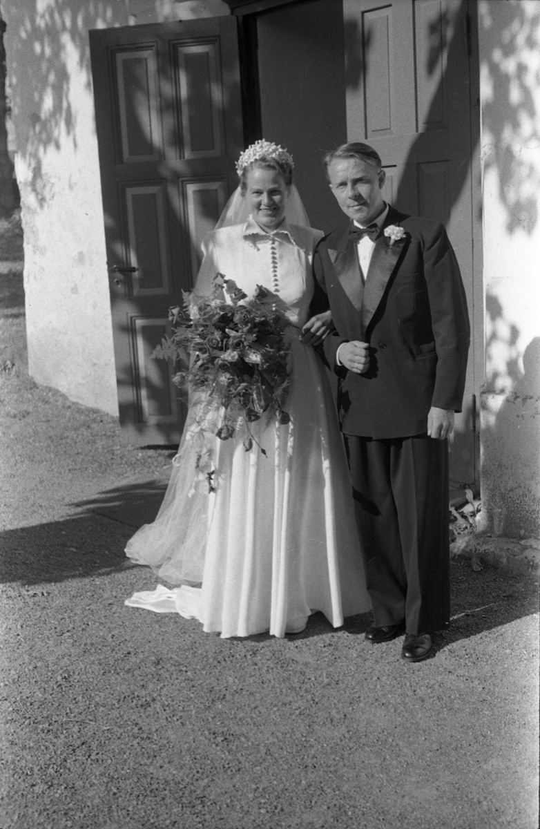 Brudeparet Else Rustad og Edvard Narum fotografert foran inngangen til Hoff kirke. Serie på 11 portretter, noen i helfigur, andre i halvfigur.