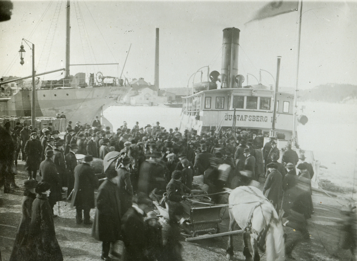 Folksamling på ångbåtskajen med Gustafsberg III i bakgrunden.
Personer: okänd