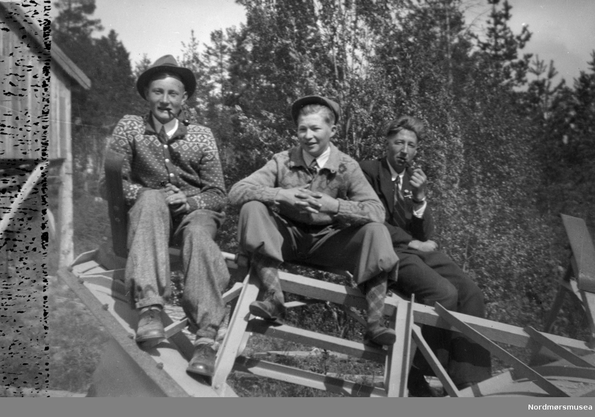 Foto av tre menn, trolig fotografert utenfor et gårdsbruk. En fotosamling fra slekten Røv på Meisingset i Tingvoll kommune. Fotografiene kan trolig dateres mellom 1950-1960. Eier av originalmaterialet er Jan Harry Røv. Fra Nordmøre museums fotosamlinger.