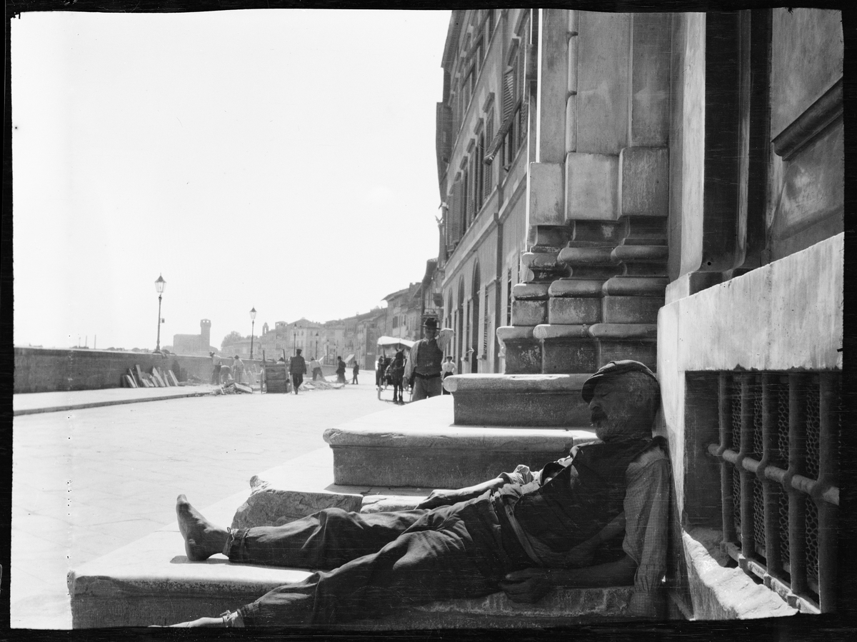 Sovande man lutad mot en husvägg. Troligen Triana eller Sevilla, Spanien