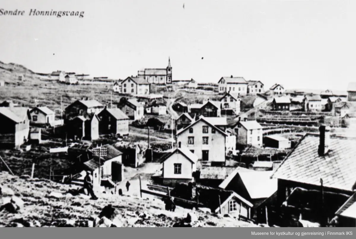 Postkortmotiv. Bebyggelsen i Honningsvåg med kirka i bakgrunnen. Ca. 1910.