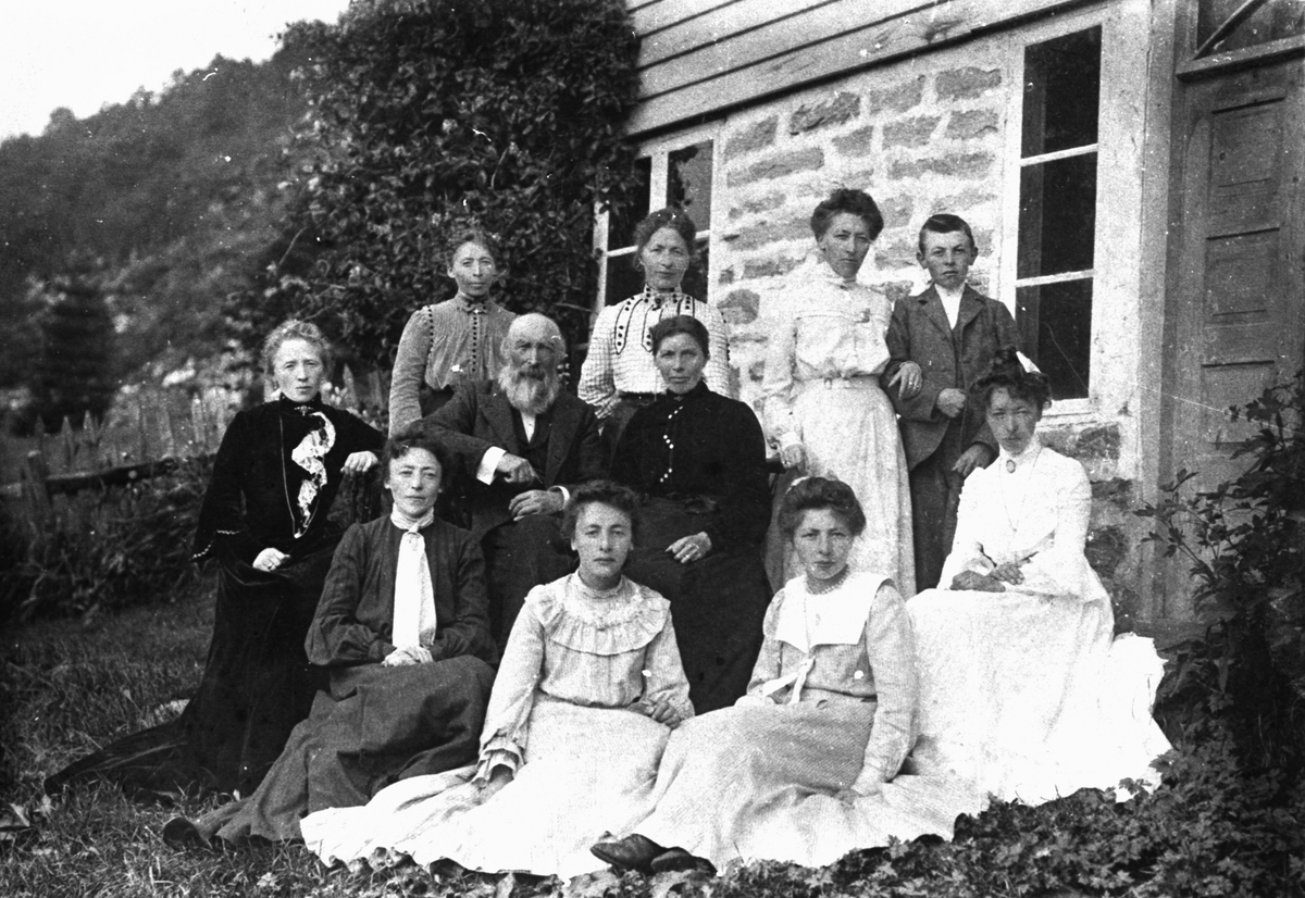 Gruppefotografi av en familie i hagen utenfor et hus. Knut D. Stafset med familie.