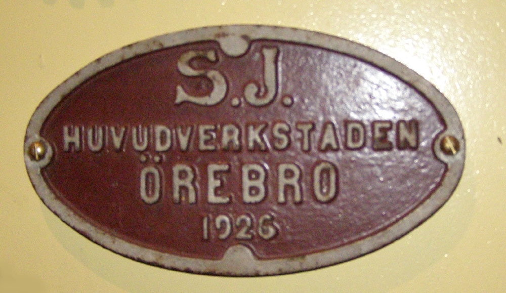 Vagntillverkarskylt av järn.
Oval och brunmålad.
SJ Huvudverkstad Örebro