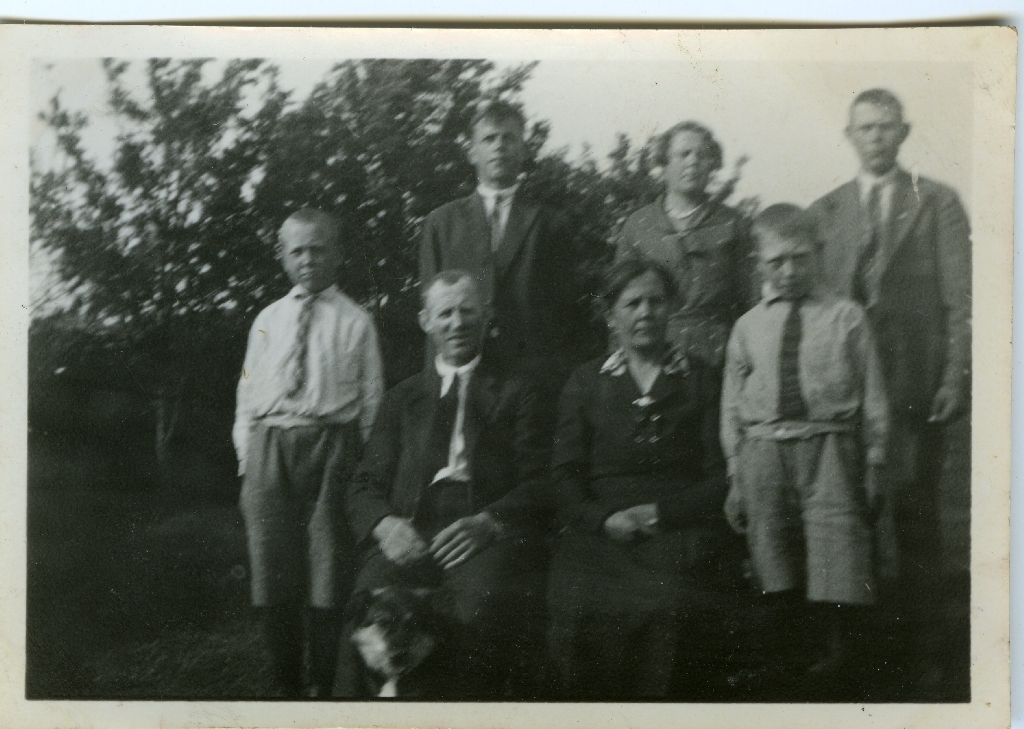 Familien Kartevoll, Lyevollen er stilt opp i hagen for fotografering. Framme f.v. : Oskar Kartevoll (15.3.1921 - ), Olav Kartevoll (18.2.1883 - 19.9.1964), Olina Kartevoll f. Undem (3.1.1886 - 25.5.1964), Kåre Kartevoll 20.12.1923 - 13.1.1995).
Bak f.v. : Haakon Kartevoll (30...1.1912 - 27.2.1904), Målfrid Kartevoll g. Høyland (8.2.1913 - 13.1.1992), Andrias Kartrevoll (28.7.1916 - 10.4.2005). Hunden har stilt seg opp framfor Olav.