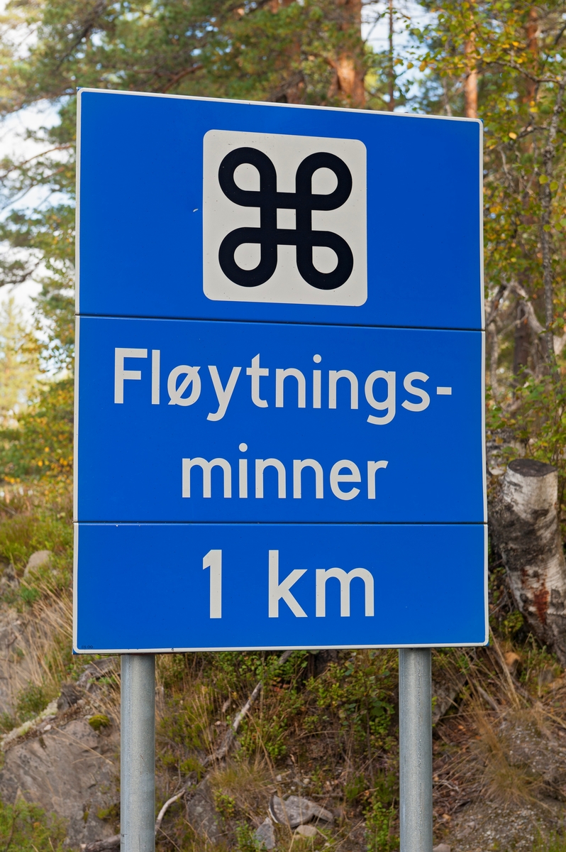 Informasjonsskilt om «fløytningsminner» ved riksveg 364 («Hovinvegen») i Notodden kommune i Telemark.  Det dreier seg om et blått skilt på to galvaniserte jernstolper.  Øverst på skiltet er det et kvitt kvadrat med en valknute – et kringleformet korssymbol – som viser at trafikantene nærmer seg severdigheter.  En kvit tekst under valknuten forteller at det dreier seg om «Fløytningsminner» med avkjøring fra Hovinvegen en kilometer lengre framme (ved Hegnadalen).  Kulturminnene det dreier seg om er Raudammen og Rautunnelen, hvor forholdene er tilrettelagt for publikum i form av en kultursti. 