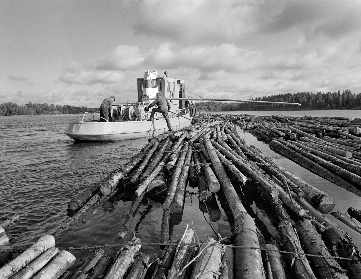 Sammenbinding av tømmerslep ved et flåtested i nordenden av Aremarksjøen i Østfold. Fotografiet er tatt i 1982, som var den siste sesongen det ble fløtet tømmer i Haldenvassdraget.  Fløtingsvirket i Haldenvassdraget ble de siste driftsåra utislått som lastebilbunter.  Disse buntene ble bundet sammen i store slep, som ble buksert over innsjøene med kraftige slepebåter som trekkraft.  Ved slusestedene måtte imidlertid slepene deles opp i kortere lenker, som fikk plass i slusekamrene.  Nedenfor slusene ble slusevendingene bundet sammen i lengre lenker igjen, og flere slike lenker ble samlet til store, rektangulære slep.  Over disse ble det spent en langsgående såkalt «revevaier» med en «hanefot» bakerst for sleping.  Det var disse vaierne slepelina ble festet i.  Her ser vi slepebåten «Mette Meng» ved siden av et slep.  Kranarmen som henger over slepet ble brukt ved utlegging av revevaieren.  Mannen som sto på akterdekket var Odd Johansen, mens Harald Gunneng var i ferd med å gå fra slepet om bord i båten.

Haldenvassdragets Fellesfløtningsforening kjøpte slepebåten Mette Meng i 1947.  Fartøyet var på det tidspunktet 25 år gammelt.  Mette Meng var nemlig bygd ved Glommens mek. Verksted i 1922.  Skroget var 14,2 meter langt, 3,5 meter bredt og det indre volumet ble oppgitt til 19 registertonn (53,8 kubikkmeter).  Fartøyet hadde opprinnelig dampmaskin, men det ble i begynnelsen av 1960-åra ombygd til dieseldrift, noe som muliggjorde en viss nedbemanning.  M/S Mette Meng ble etter avviklinga av tømmerfløtinga i 1982 solgt til John Floeng, Reni Braarud og Preben Poulsen på Ørje.  Haldenvassdragets Fellesfløtningsforening valgte å gi båten navn etter ei framtredende kvinne fra Haldens gamle trelasthandleraristokrati.  Personen Mette Meng (død 1696) var datter av kjøpmann Nils Hanssøn Meng (1604-1676), som var blant dem som ivret sterkest for at Halden skulle få kjøpstadrettigheter.  Seinere ble han magistratpresident i byen.  Dattera Mette var blant partisipantene i sagbrukskompaniet Tista, en av forløperne for sagbruks- og treforedlingsselskapet Saugbrugsforeningen.  Mette var først gift med den rike kjøpmannen og offiseren Peder Olssøn Nordmand (død 1676), deretter med en annen framstående trelasthandler, visepresident Niels Stub (1638-1723).  

En liten historikk om tømmerfløting og kanaliseringsarbeid i Haldenvassdraget finnes under fanen «Opplysninger».