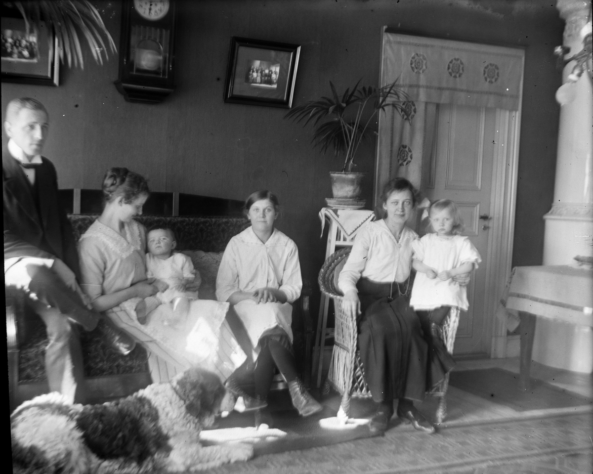 Kvinnor, man, barn och hund i hemmiljö, Uppland 1919