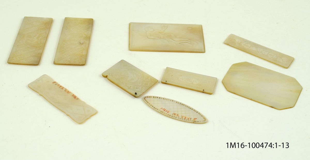 Skivor av pärlemor i olika storlekar, med olika former och med olika motiv på skivorna.