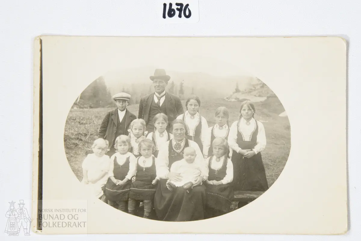 Fotografi, svart-kvitt. Familieportrett av mann og kvinne med dei 11 borna.