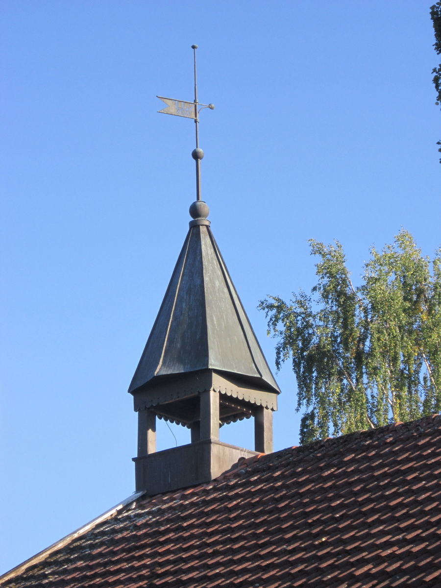 Klokketårnet på Frenning vestre har kjegleformet tak. Tårnet står på stabburet, og er i god stand.