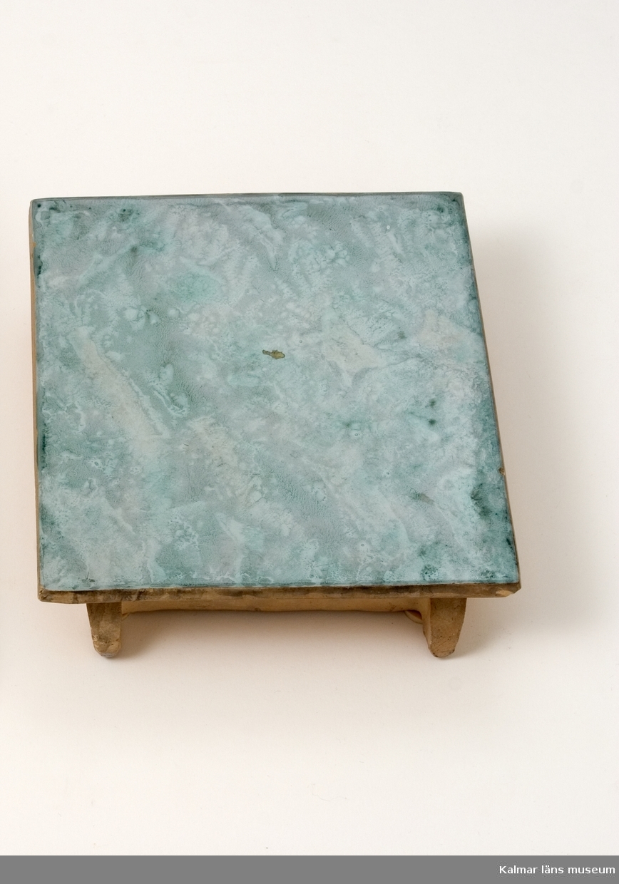 KLM 39887:2. Kakel, av gulbränd lera. Flat, slät yta, dekor, marmorerad med tryck av trasa i flera gröna nyanser på grå bottenfärg, stämpel: KS.