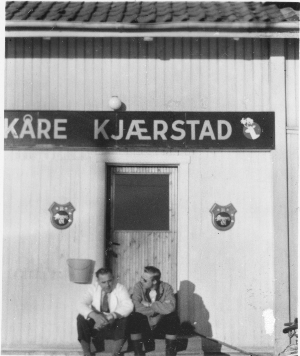 To menn sitter på trappa utenfor Kåre Kjærstad sin landhandel. Kåre Kjærstad til venstre.