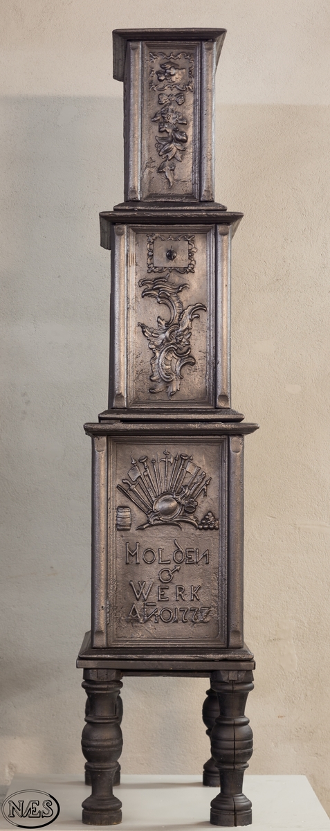 Ovn i 3 etasjer med hovedmotivet, Venus krever våpen til Æneas, på begge langsider 1. etasje.  Øverst på kortsidene 1. etasje krigerske emblemer. 2. og 3. etasje rokokko-ornamentik med uregelmessig åpning. Kortsidene med blad og blomster i sløyfe.