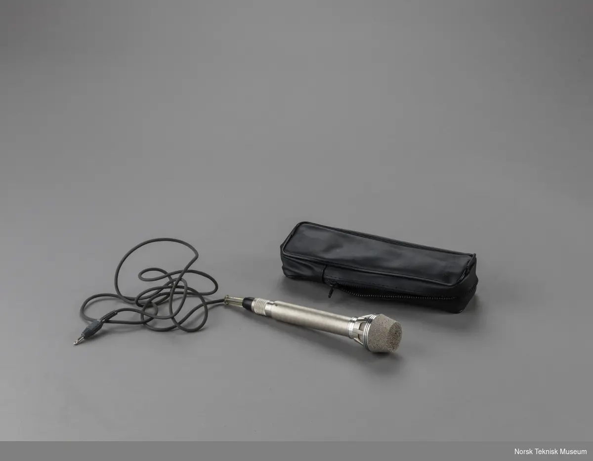 Sølvgrå mikrofon med ledning med mini-jack-plugg, samt øreplugg i sort veske.