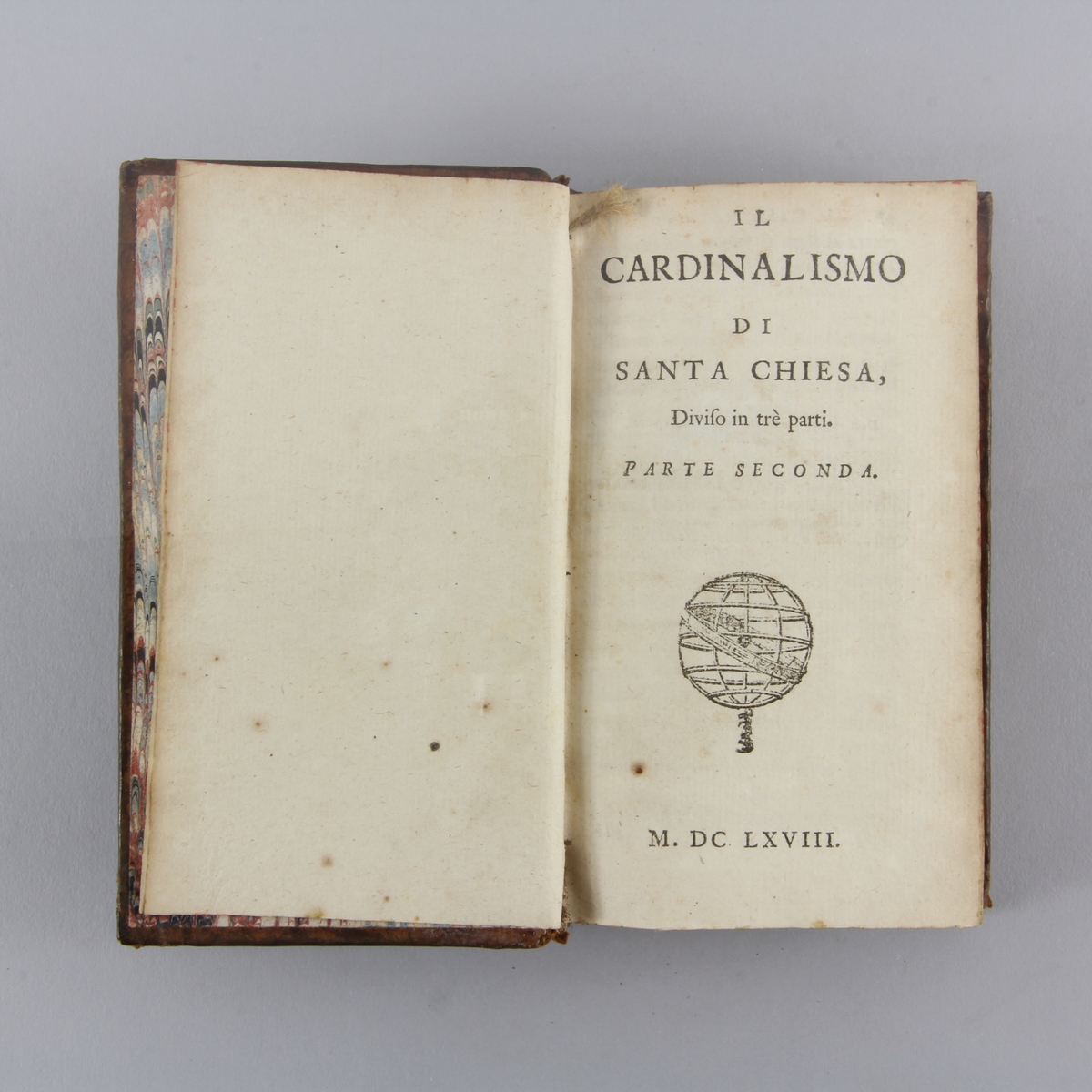 Bok, helfranskt band "Il cardinalismo di Santa Chiesa", del 2. Skinnband med guldpräglad rygg i fem upphöjda bind, marmorerat papper på pärmens insida. Rödstänkt skuret snitt.