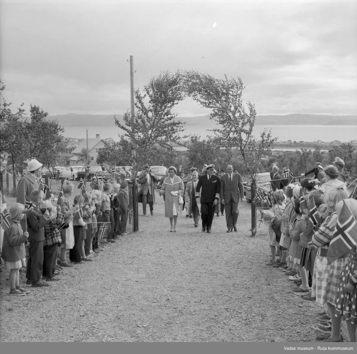 Vestre Jakobselv juli 1959. Kongen med følge ankommer barnehjemmet Vårsol. Fra venstre: prinsesse Astrid, fylkesmann Peder Holt,, Kong Olav og ordfører i Nord-Varanger, Henry Karlsen.