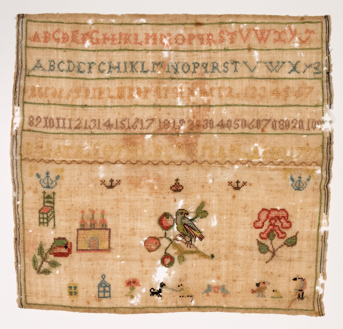 Märkduk av ull med silke eller linbroderi. Motivet är bokstäver, arabiska siffror, kronor, stol, blommor, fåglar, hus, hundar. Märkt Beata Sophi Bergman Anno 1797.