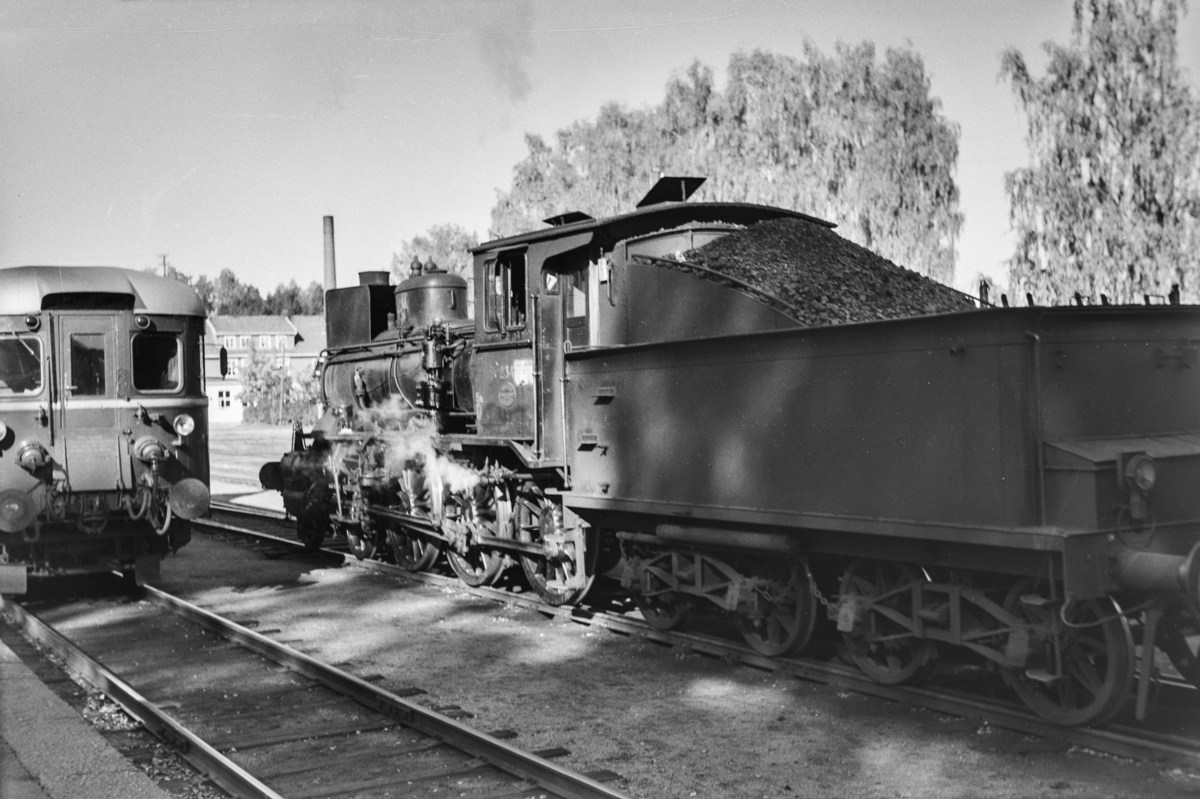 Kryssing mellom godstog og persontog på Flisa stasjon. Godstoget trekkes av damplokomotiv type 27a nr. 234.