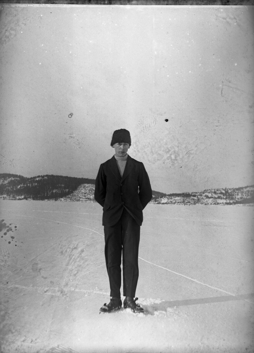 Hugo Larsson fotograferad vid en skridskofärd på Mjörn. Hugo bär svart sportkostym, svart mössa och ljus polo. Sjön är täckt av snö.