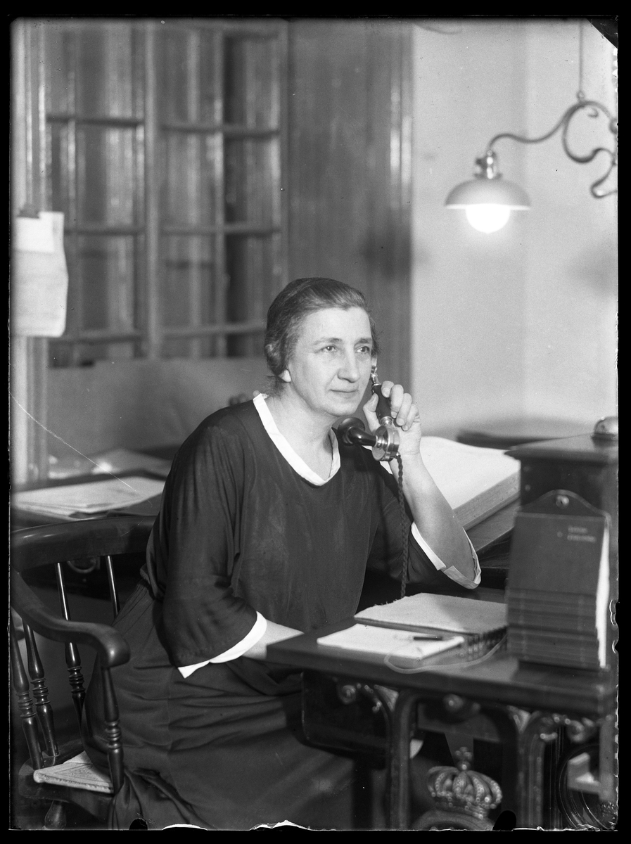 Anna Lenander porträtterad när hon pratar i telefonen. Framför sig har hon block och penna.