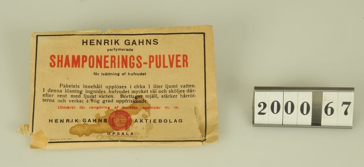 Pappersförpackning med pulver för hårtvätt.
"Henrik Gahns Shamponerings-pulver för tvättning af hufvudet".
Funktion: För hårtvätt