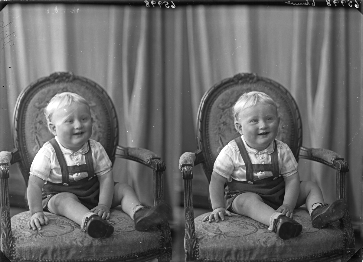 Portrett. Ung lyshåret gutt i kort snekkerbukse med hvit skjorte sittende i en brodert stol. Bestilt av Hans Røkenes. Førde. Hordaland.