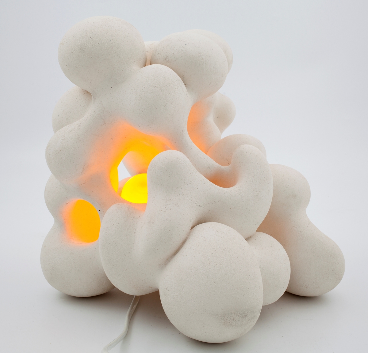 Hvit lampe i keramikk. Formet av sammensmeltede bobleformer.