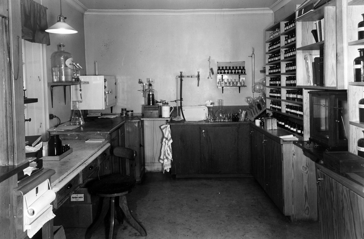 Ett av arbetsrummen i apoteket Hjorten. Rummet kallades "Analysen". Till höger hyllor med glasflaskor, mitten provrör och provrörställningar och till vänster en arbetsyta.