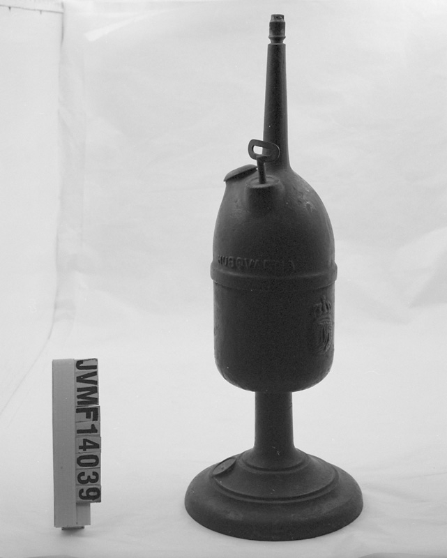 Karbidlampa av brunt gjutjärn med liten fot.

Historik: Föremålet är en s k kristidseffekt från kristiden under första världskriget.
