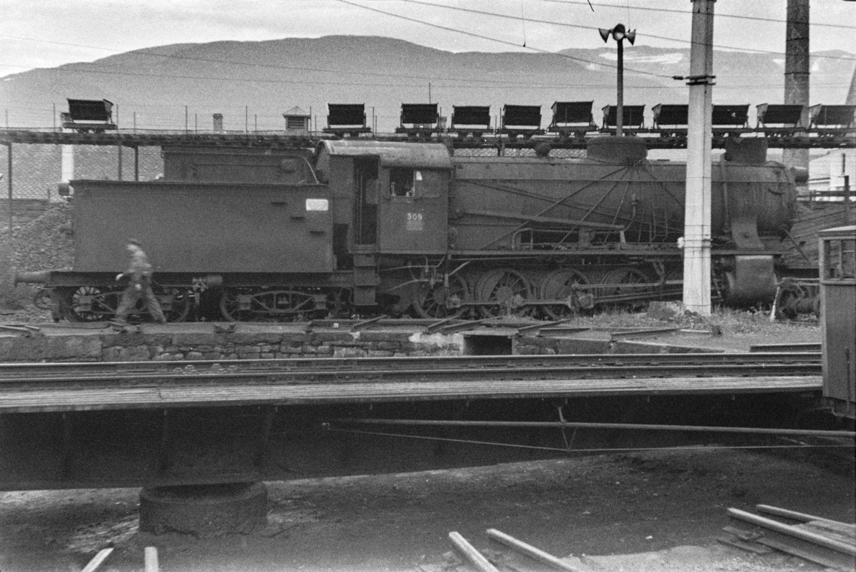Utrangert damplokomotiv type 39a nr. 309 på Voss stasjon. I bakgrunnen transportanlegg med vagger for kull til lokomotivene.