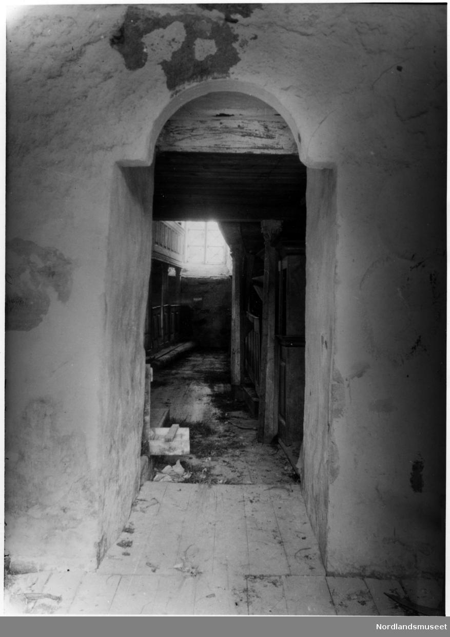 Gildeskål. Gildeskål kirkested. Portalen inn fra våpenhuset til Gildeskål gamle kirke, 1925. Høydotter og sauskit på gulvet. Murpuss skaller av.