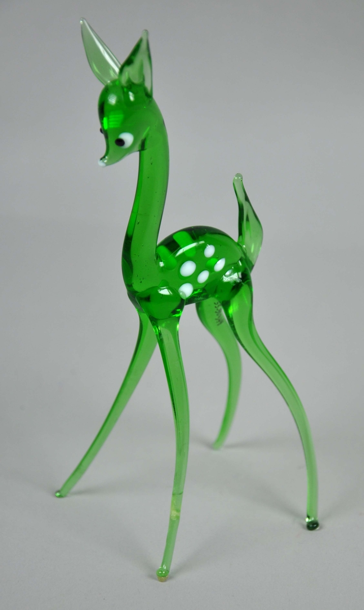 Grønn glassfigur formet som et rådyr eller dådyr. Figuren er reparert med lim.