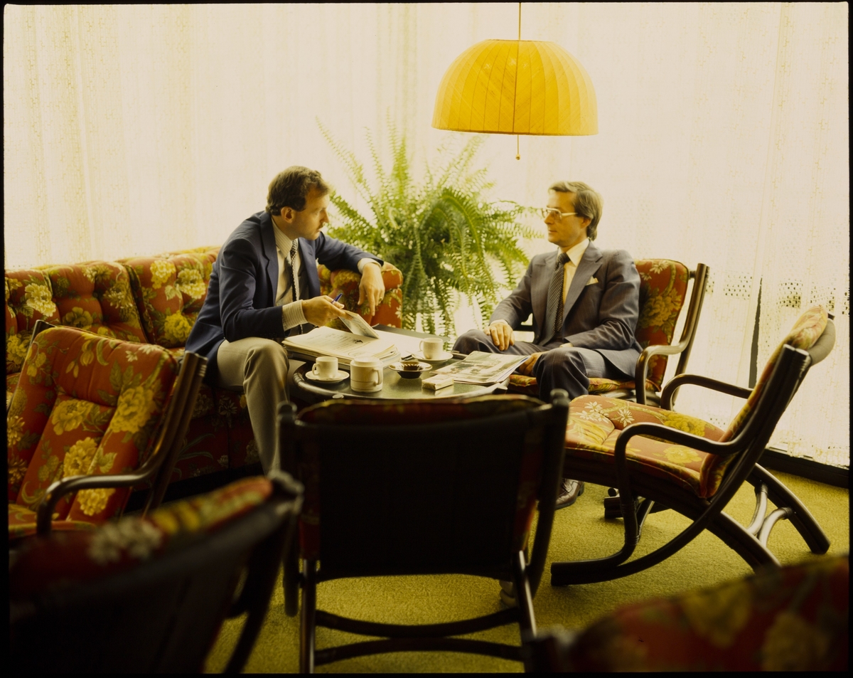 To menn snakker sammen i en sofagruppe på Hotell Saga.