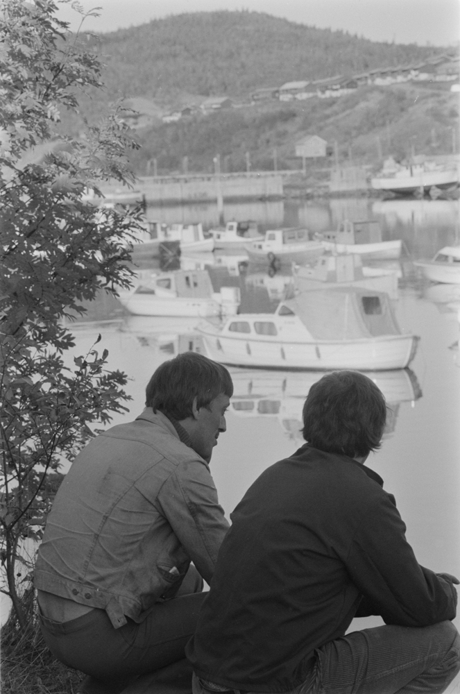 Småbåthavna i Mosjøen 1979.
2 menn som sitter på huk ved havna.