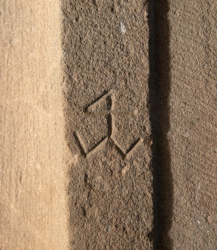 Steinhuggermerke fra middelalderen, formen likner på et stilisert og kantete anker.