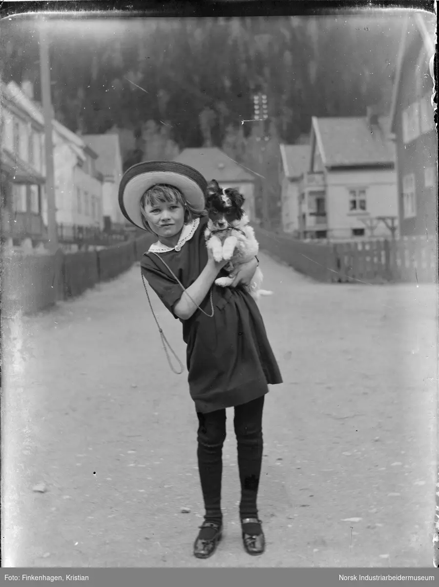 Liten jente med hund på armen i Haraldsgate.