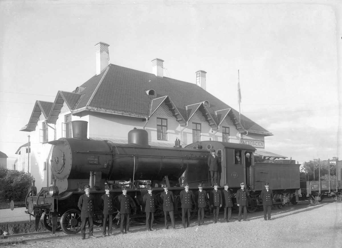 Personal från Stockholm - Västerås - Bergslagens Järnväg vid Smedjebackens station framför loket SWB M 64.