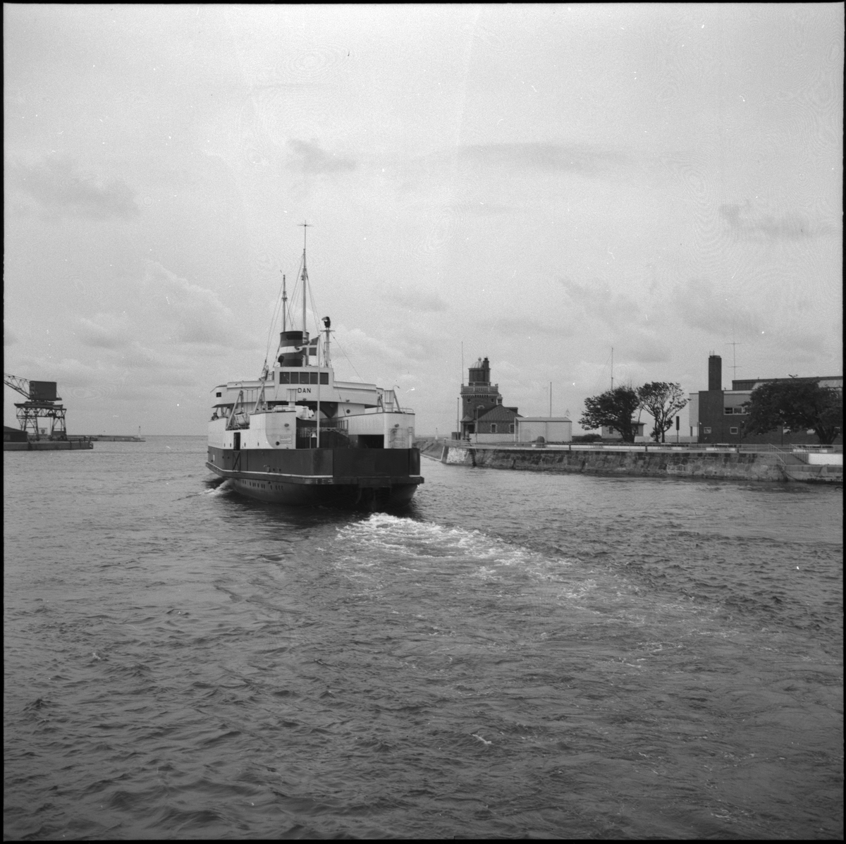 Helsingborg. Utsikt från Kärnan, Busstorget. Fartyget Dan lägger ut från hamn. S/S Dan ägdes av DSB (Danske Statsbaner) och trafikerade Helsinborg - Öresund från 1935 till 1973. I och med invigningen av Öresundsbron år 2000 upphörde tågfärjetrafiken, då tågen därefter endast färdades över bron