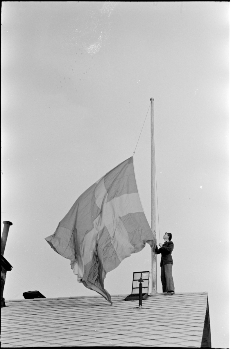 Flagga hissas vid Charlottenberg station, i samband med transport av norska krigsfångar frigivna från det nazistiska interneringslägret Grini strax efter Tysklands kapitulation.
