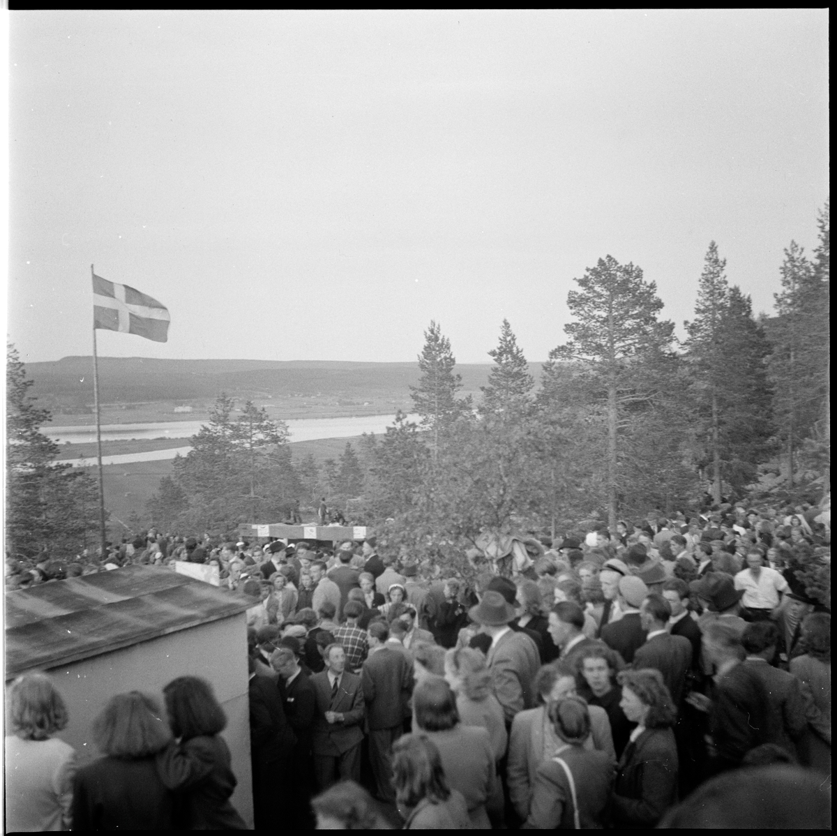 Ett stort antal människor har samlats på Luppioberget mellan Övertorneå och Hedenäset. I bakgrunden syns Torneälven och på andra sidan denna Finland.