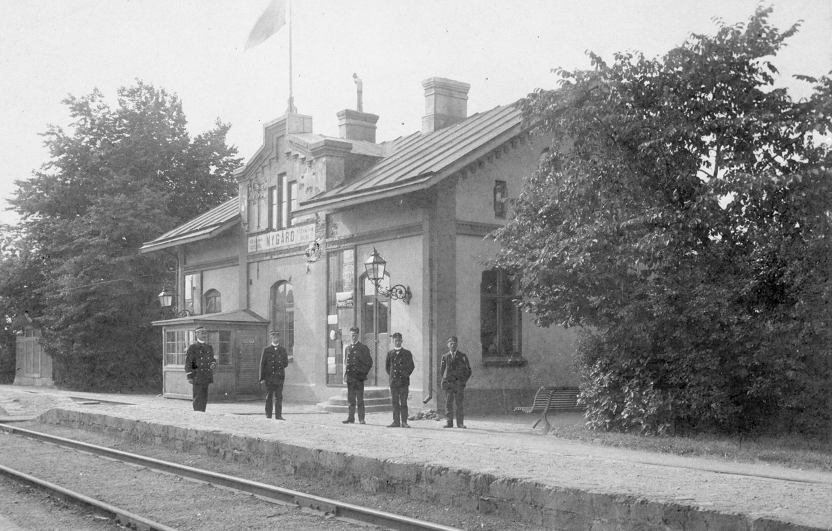 Nygård järnvägsstation med personal framför stationshuset..