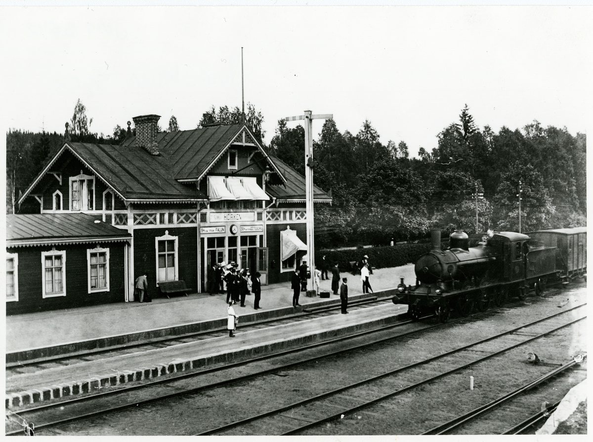 Hörkens station med många resande på plattformen.