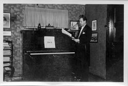 Gottfred Pedersen stående ved pianoet i stua i Amtmannsgt. 7