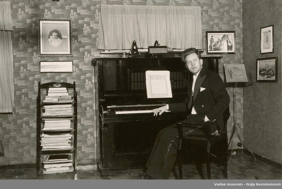 Gottfred Pedersen sittende ved pianoet i stua i Amtmannsgt. 7 i Vadsø. Ca 1938