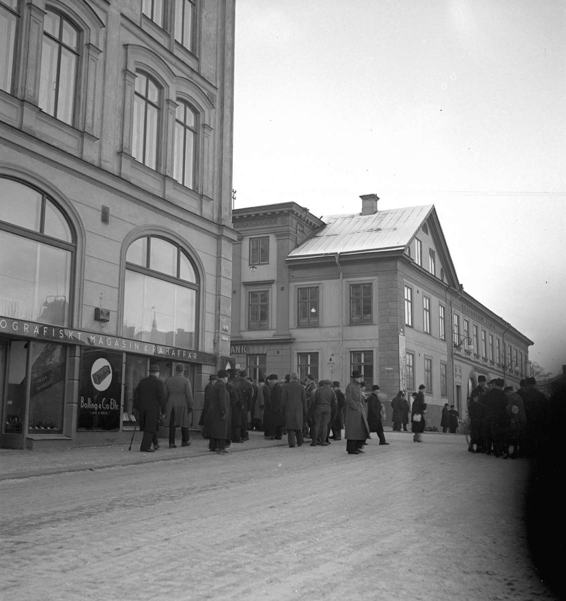 Hindersmässan i Örebro den 26 januari 1937. Folk promenerar utanför Stora Hotellet strax intill korsningen mellan Drottninggatan och Engelbrektsgatan. Fenixhuset är synligt i bakgrunden.