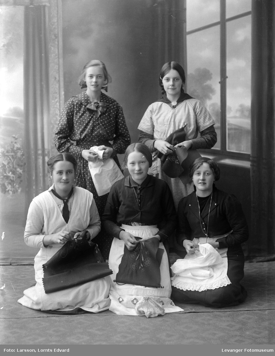 Gruppebilde av fem unge kvinner, viser frem sitt syarbeide