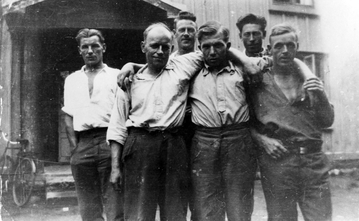Sex män ur ett "rallaregäng" står framför en träbyggnad. Med som AK-arbetare var metallarbetaren Folke Augustsson från Alingsås.