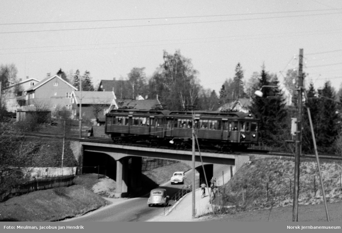 Motorvogntog på Røabanen passerer viadukten over Sørkedalsveien ved Huseby skole.