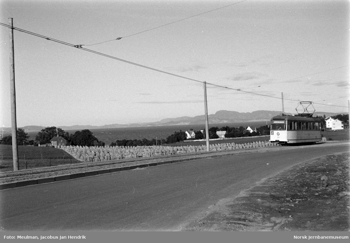 Trondheim Sporvei nyeste sporvogn nr. 32 til Elgeseter på enkeltsporstrekningen på rute 2 mellom Fagerheim og Ringve skole. Til venstre jordbruksarealene ved Østmarka sykehus, Trondheimfjorden og bak trikken til venstre Forbordsfjellet.